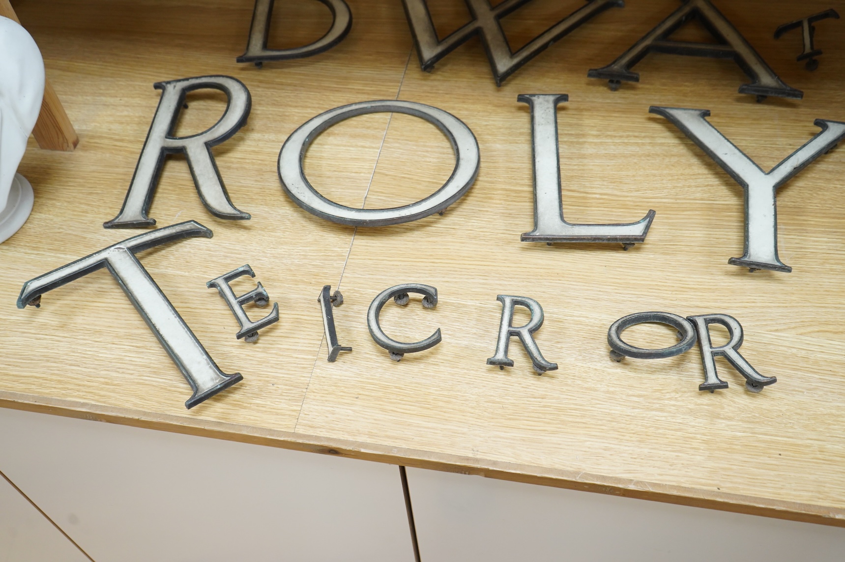 A part set of fifteen enamelled brass letters, largest 23cm